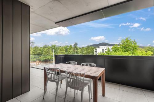 a dining room with a table and chairs on a balcony at Stylish 2-Bed in Braddon with Alfresco Dining in Canberra