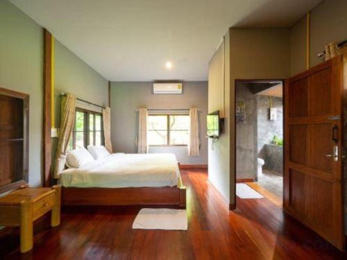 une chambre avec un lit et une grande fenêtre dans l'établissement The Frog Khao Yai Resort, à Ban Tha Chang