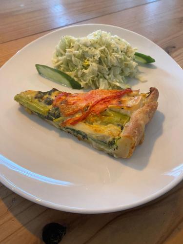 un piatto bianco con un pezzo di cibo e insalata di cavolo di Japan Snowsports a Iiyama