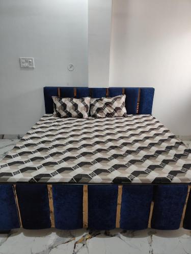 a blue bed with a black and white comforter at Narayan Home Stay in Ujjain