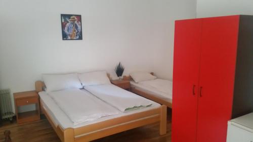 a room with two beds and a red cabinet at Apartments Agape in Belgrade