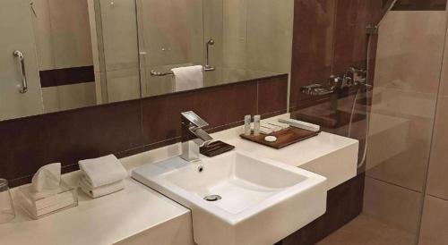 ein Badezimmer mit einem weißen Waschbecken und einem Spiegel in der Unterkunft Hotel 61 Medan in Medan