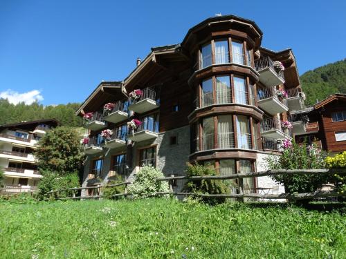 a large building with balconies on the side of it at Hotel Phoenix in Zermatt