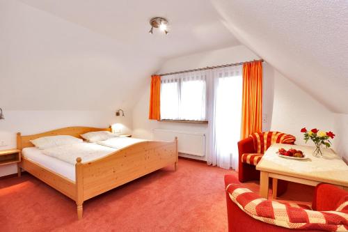 1 dormitorio con 1 cama, mesa y sillas en Pension Waldwinkel, en Lenzkirch