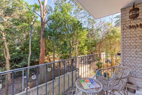 a balcony with a table and chairs and trees at Lovely Harbourside 1-Bed Close To Sydney Landmarks in Sydney