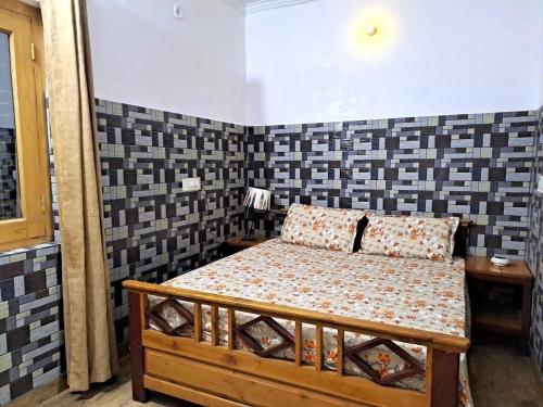 - une chambre avec un lit dans une pièce dotée de murs carrelés dans l'établissement Gopi Homestay & Restaurant - Jim Corbett, à Tota Ām