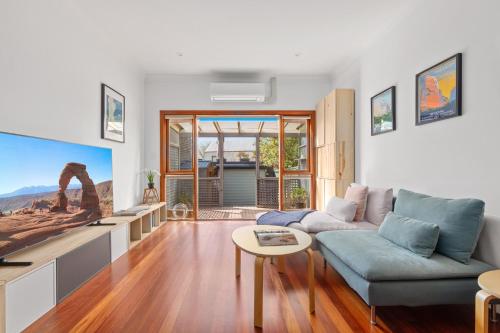 a living room with a couch and a table at Stylish 2-Bed Cottage in Trendy Erskineville in Sydney