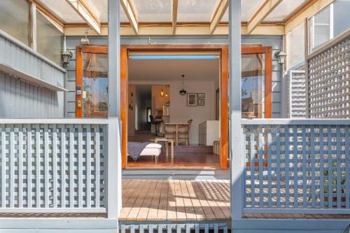 a pivot door to a house with a porch at Stylish 2-Bed Cottage in Trendy Erskineville in Sydney