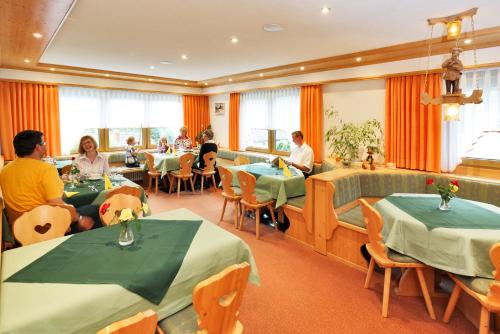 a restaurant with tables and people sitting at tables at Pension Waldwinkel in Lenzkirch