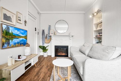 un salon blanc avec un canapé et une cheminée dans l'établissement Charming 1-Bed with Fireplace by the Beach, à Melbourne