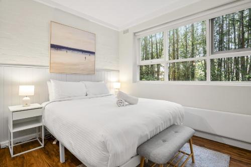 une chambre blanche avec un grand lit et deux fenêtres dans l'établissement Charming 1-Bed with Fireplace by the Beach, à Melbourne