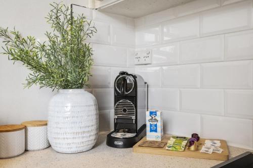 a kitchen counter with a toaster and a vase with a plant at Charming 1-Bed with Fireplace by the Beach in Melbourne