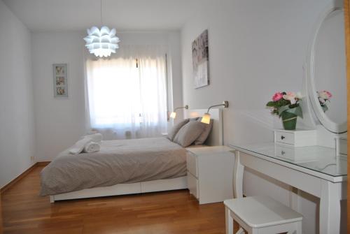 a white bedroom with a bed and a mirror at Parque Nacoes Prime Apartments 13 in Lisbon