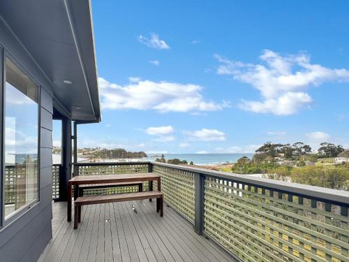 a bench on a balcony with a view of the ocean at 2-Bed Beach Haven with Garden & Alfresco Dining in Malua Bay