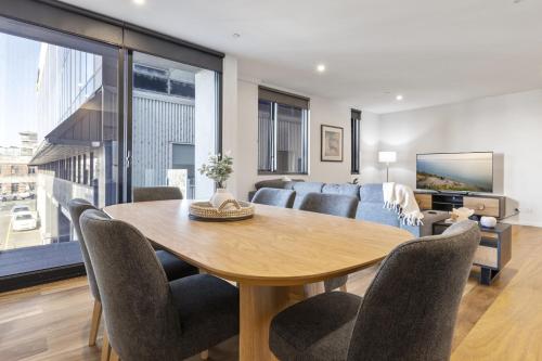 a living room with a table and a couch at Oceanfront 2-Bed With Balcony & Study Nook in Geelong