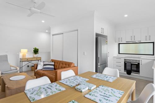 a kitchen and living room with a table and chairs at Riverside 3-Bed Home with Study Nook and BBQ in Strathpine