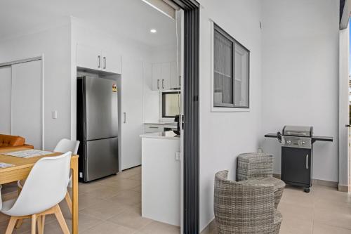 a kitchen and dining room with a table and chairs at Riverside 3-Bed Home with Study Nook and BBQ in Strathpine