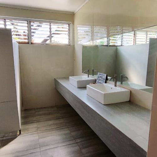 a bathroom with two sinks and two mirrors at RiverCoves Resorts in Bulakan