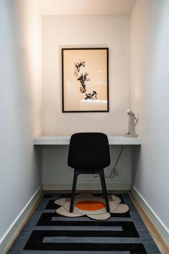 a black chair in a room with a white wall at "Nott's Nook"- 1-Bed with Rooftop Views in Melbourne