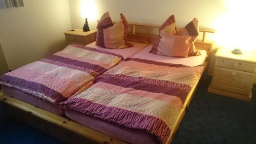 sypialnia z 2 łóżkami z poduszkami różowymi i fioletowymi w obiekcie Ferienwohnung An der Loreley w mieście Bornich