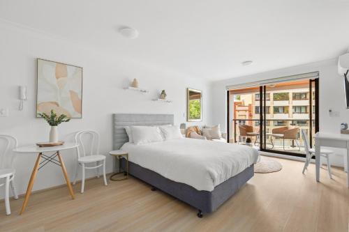 a bedroom with a bed and a table and chairs at Ideal Studio Inner-City Pad with Private Balcony in Sydney