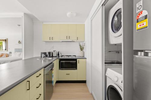 a kitchen with a sink and a washer and dryer at Ideal Studio Inner-City Pad with Private Balcony in Sydney