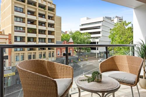 a balcony with chairs and a table and a view of a city at Ideal Studio Inner-City Pad with Private Balcony in Sydney