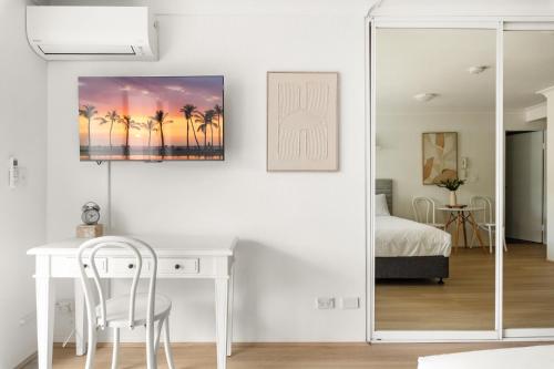 a white room with a desk and a bedroom at Ideal Studio Inner-City Pad with Private Balcony in Sydney