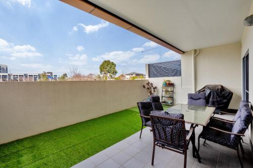 a patio with a table and chairs and a green lawn at Ground Level 1-Bed: Courtyard & Alfresco Dining in Weston Creek