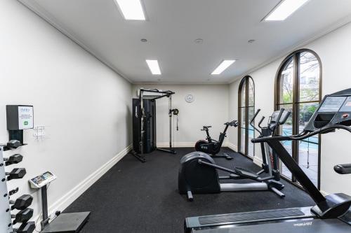 a gym with two treadmills and two ellipticals at Chic 1-Bed in East Melbourne with Gym & Pool in Melbourne