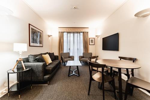 a living room with a couch and a table at Chic 1-Bed in East Melbourne with Gym & Pool in Melbourne