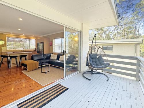 a porch with a chair and a living room at Pet-Friendly 2-Bed Beach House with Garden & BBQ in Surf Beach
