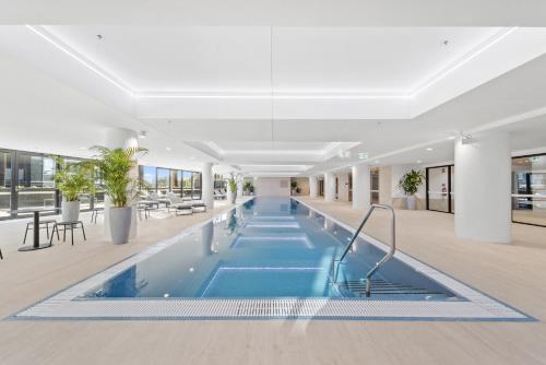 an indoor pool in a building with tables and chairs at Phillip 2-Bed: Chic Interiors Amazing Amenities in Phillip
