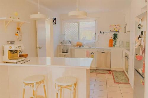 a kitchen with a counter and two stools in it at Harbour Town Cozy Suite in Gold Coast
