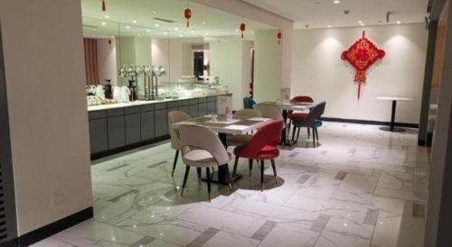 ein Esszimmer mit einem Tisch, Stühlen und einer Theke in der Unterkunft Jinjiang Inn Tianjin Station Jinwan Square in Tianjin