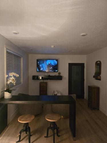 uma sala de estar com uma secretária e 2 bancos em Comfortable Luxury Studio em Northridge