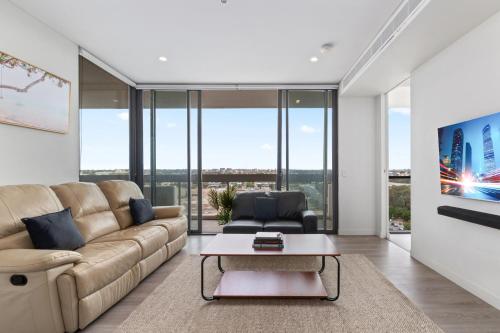 a living room with a couch and a table at Luxe 2-Bed: Modern Interiors Balcony & BBQ Area in Sydney