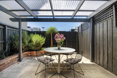 a patio with a table and chairs on a patio at Charming 2-Bed Home with Outdoor Space in Cremorne in Melbourne