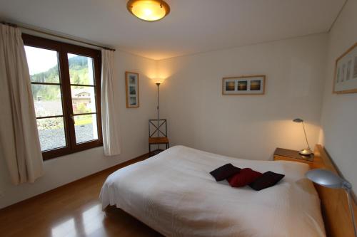 - une chambre avec un lit blanc et 2 oreillers dans l'établissement Rosat 4, à Château-d'Oex