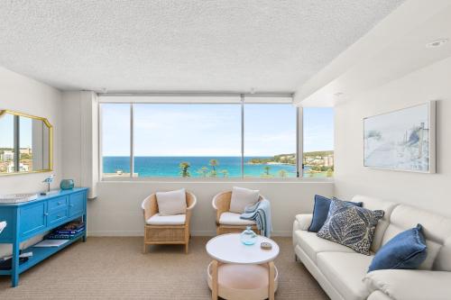 a living room with a couch and a table at Wake Up to the Ocean: 1-Bed with Pool & Views in Sydney