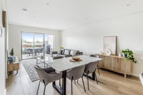 a living room with a table and a couch at Lovely 3-Bed with Alfresco Dining by Attractions in Kiama
