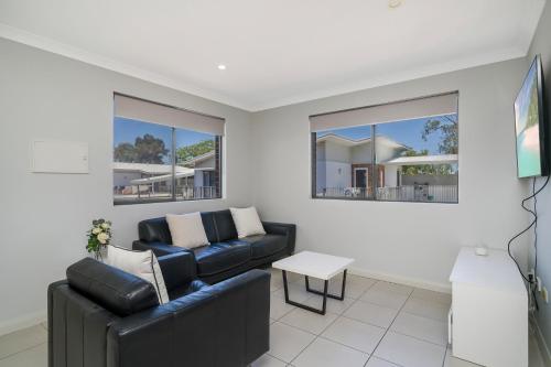 a living room with a couch and a table at Sunny 2-Bed in Quiet Location with Balcony in Perth