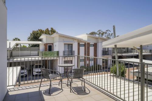 a patio with chairs and tables on a balcony at Sunny 2-Bed in Quiet Location with Balcony in Perth