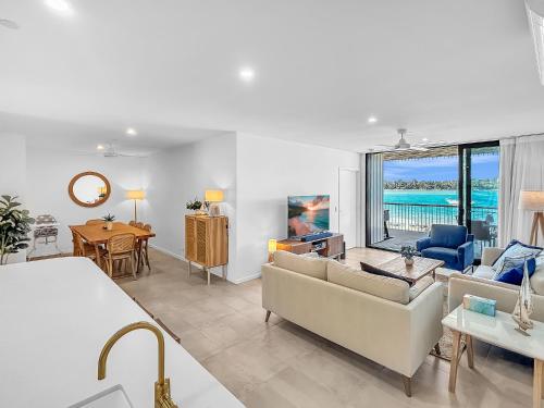 a living room with a view of the ocean at 3-Bed: Riverfront Alfresco Dining & Rooftop Pool in Batemans Bay