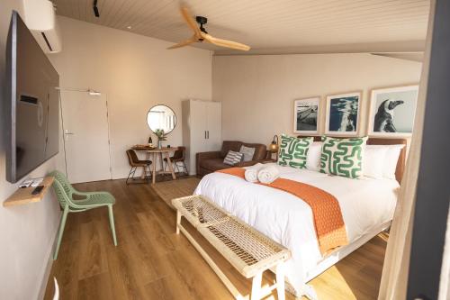 赫曼努斯Oceanfront Studios - Hermanus Waterfront Apartments的带一张大床和一张沙发的卧室