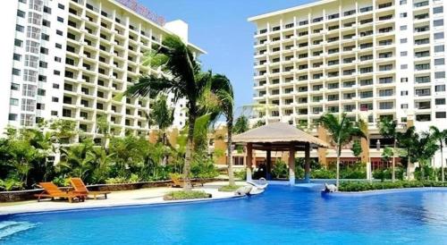 ein großes Schwimmbad vor zwei Gebäuden in der Unterkunft Yuhai International Resort Hotel in Sanya