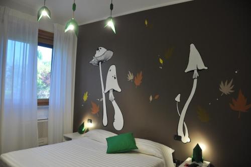 una camera da letto con un letto con foglie sul muro di Lo Scoiattolo Piedmont Bike Hotel a Pralormo