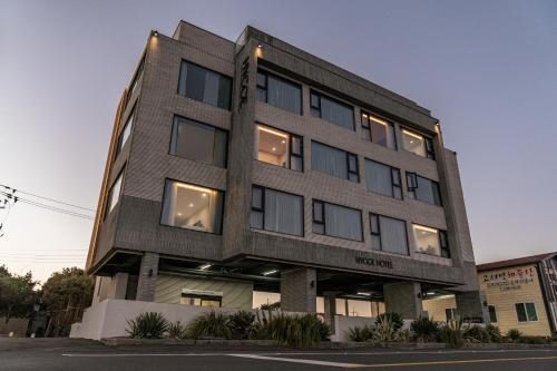 ein hohes Gebäude mit Fenstern zur Straße in der Unterkunft Hygge Hotel in Seogwipo