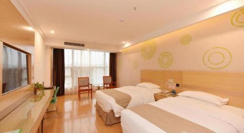 a hotel room with two beds and a television at GreeTree Inn Huainan Jinjialing Road Oriental General Hospital in Huainan