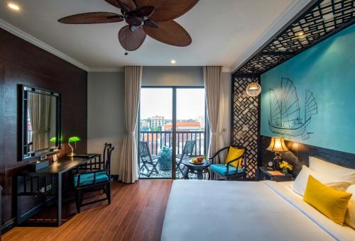 - une chambre avec un lit, un ventilateur de plafond et un bureau dans l'établissement Anio Boutique Hotel Hoian, à Hội An